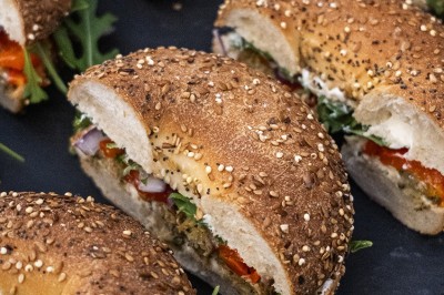 Salle de réception spacieuse avec tables rondes dressées, chaises blanches et éclairage doux.