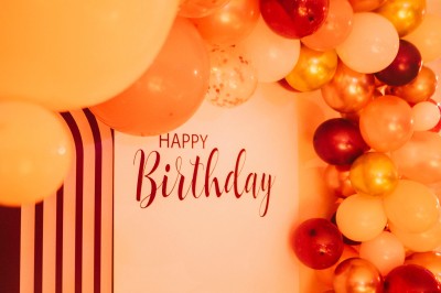 Salle de réception spacieuse avec tables rondes dressées, chaises blanches et éclairage doux.