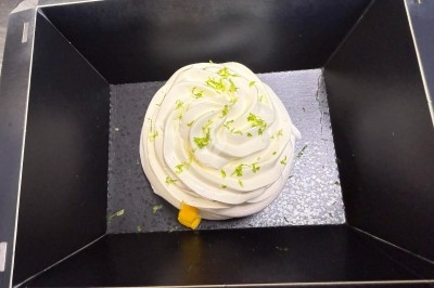 Tour de choux garnis, assemblés avec du caramel et décorés de fleurs en sucre roses et bleues.