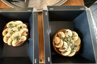 Tour de choux garnis, assemblés avec du caramel et décorés de fleurs en sucre roses et bleues.