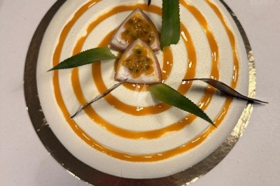 Tour de choux garnis, assemblés avec du caramel et décorés de fleurs en sucre roses et bleues.