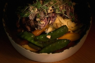 Tour de choux garnis, assemblés avec du caramel et décorés de fleurs en sucre roses et bleues.