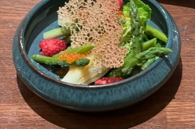 Tour de choux garnis, assemblés avec du caramel et décorés de fleurs en sucre roses et bleues.