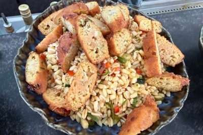 Tour de choux garnis, assemblés avec du caramel et décorés de fleurs en sucre roses et bleues.