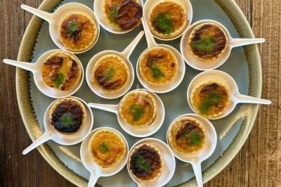 Tour de choux garnis, assemblés avec du caramel et décorés de fleurs en sucre roses et bleues.