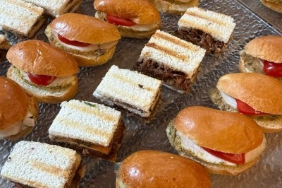 Tour de choux garnis, assemblés avec du caramel et décorés de fleurs en sucre roses et bleues.