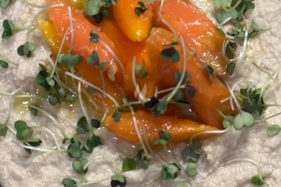 Tour de choux garnis, assemblés avec du caramel et décorés de fleurs en sucre roses et bleues.