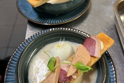 Tour de choux garnis, assemblés avec du caramel et décorés de fleurs en sucre roses et bleues.