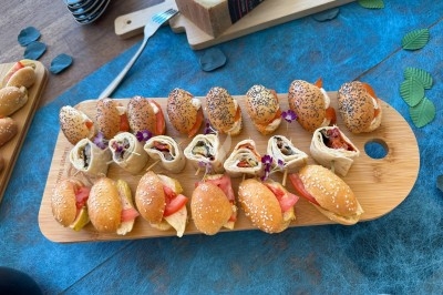 Plateaux en bois avec fromages suisses, petits pains garnis et amuse-bouches décorés de fleurs comestibles.