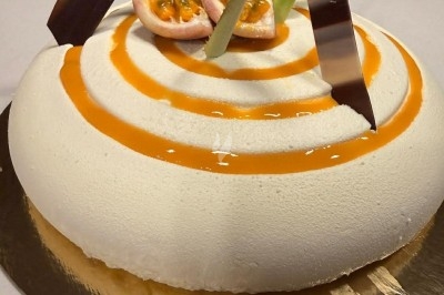 Tour de choux caramélisés décorée de fleurs en sucre roses et bleues, assemblée pour un dessert festif.