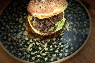 Tour de choux caramélisés décorée de fleurs en sucre roses et bleues, assemblée pour un dessert festif.