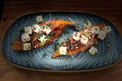 Tour de choux caramélisés décorée de fleurs en sucre roses et bleues, assemblée pour un dessert festif.