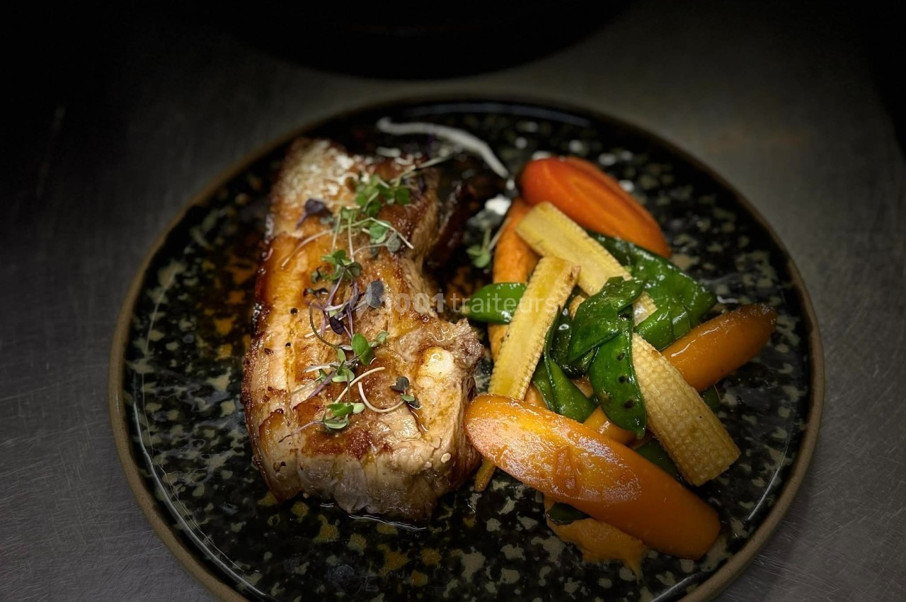 Plat de poisson grillé accompagné de légumes variés, dont carottes, mini-maïs et pois gourmands, servi sur une assiette…