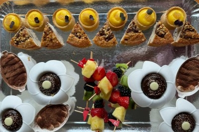 Tour de choux caramélisés décorée de fleurs en sucre roses et bleues, assemblée pour un dessert festif.