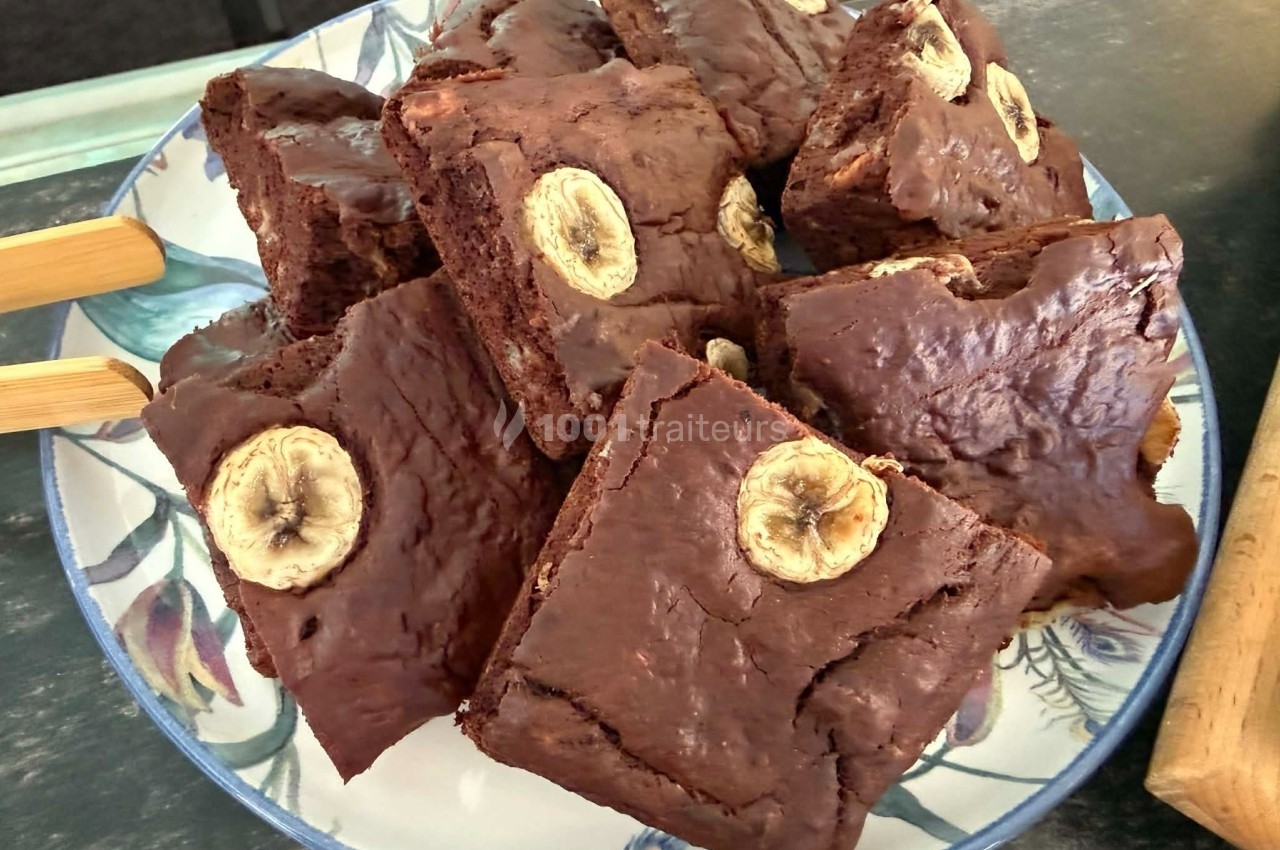 Assiette de brownies au chocolat garnis de rondelles de banane, présentés sur une table.