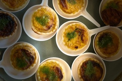 Tour de choux caramélisés décorée de fleurs en sucre roses et bleues, assemblée pour un dessert festif.