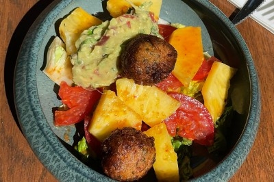 Tour de choux caramélisés décorée de fleurs en sucre roses et bleues, assemblée pour un dessert festif.