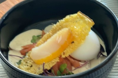 Tour de choux caramélisés décorée de fleurs en sucre roses et bleues, assemblée pour un dessert festif.