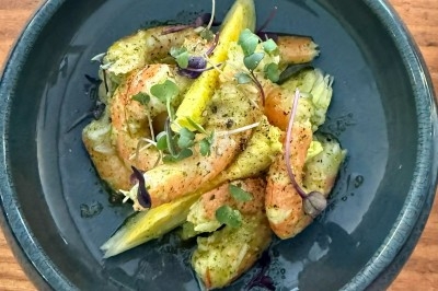 Tour de choux caramélisés décorée de fleurs en sucre roses et bleues, assemblée pour un dessert festif.