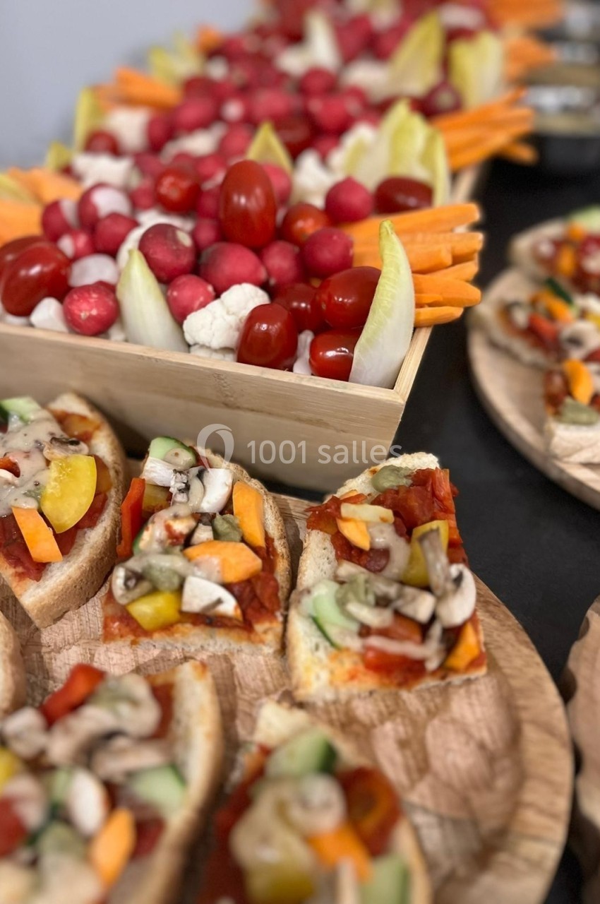Plateaux de légumes frais, crudités et bruschettas garnies de légumes colorés sur une table.