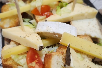 Miniature Traiteur Marseille 11 (Bouches-du-Rhône) - Les Very Traiteur #38 Calamar farci servi dans une sauce crémeuse aux herbes, présenté dans une assiette noire.