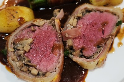 Miniature Traiteur Marseille 11 (Bouches-du-Rhône) - Les Very Traiteur #40 Calamar farci servi dans une sauce crémeuse aux herbes, présenté dans une assiette noire.