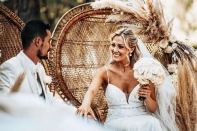 Illustration de deux oliviers entourant des tables et chaises disposées en extérieur, décorées de guirlandes lumineuses.