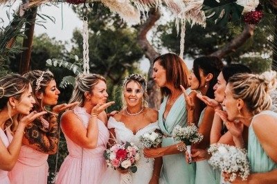 Illustration de deux oliviers entourant des tables et chaises disposées en extérieur, décorées de guirlandes lumineuses.