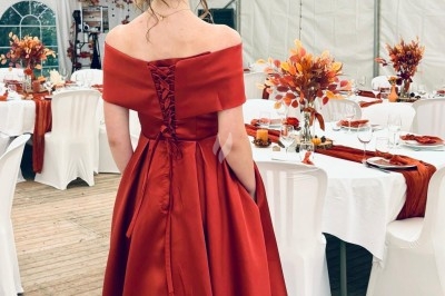 Illustration de deux oliviers entourant des tables et chaises disposées en extérieur, décorées de guirlandes lumineuses.