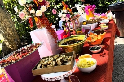 Des invités assis à des tables décorées de fleurs et feuillages d'automne dans une grande tente lumineuse.