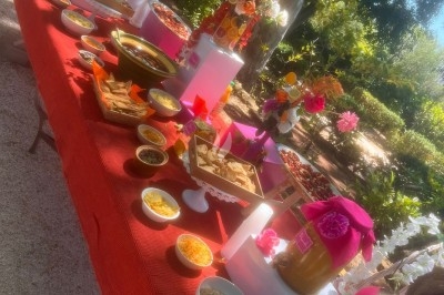 Des invités assis à des tables décorées de fleurs et feuillages d'automne dans une grande tente lumineuse.