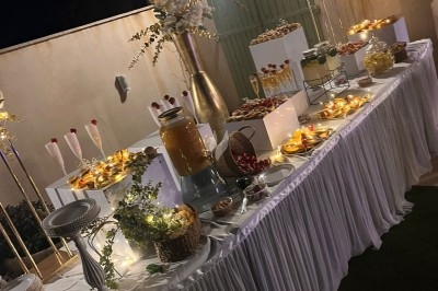 Des invités assis à des tables décorées de fleurs et feuillages d'automne dans une grande tente lumineuse.