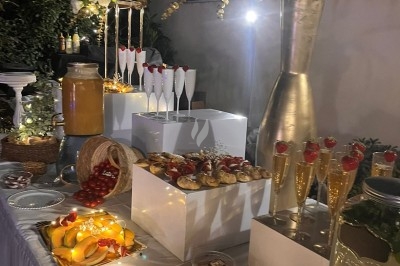 Des invités assis à des tables décorées de fleurs et feuillages d'automne dans une grande tente lumineuse.