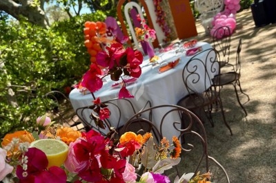 Des invités assis à des tables décorées de fleurs et feuillages d'automne dans une grande tente lumineuse.