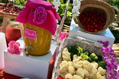 Des invités assis à des tables décorées de fleurs et feuillages d'automne dans une grande tente lumineuse.