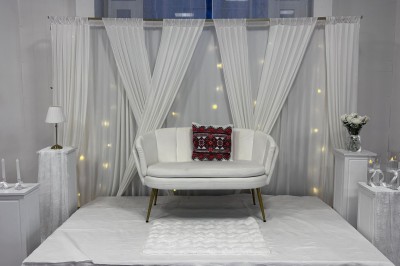 Tables de pique-nique en bois sur une terrasse en béton, entourées de pelouse et d'arbres sous un ciel nuageux.