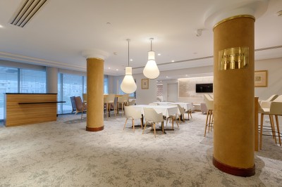 Buffet de petit-déjeuner avec viennoiseries, fromages, charcuterie, pain et confitures, dans une salle lumineuse.