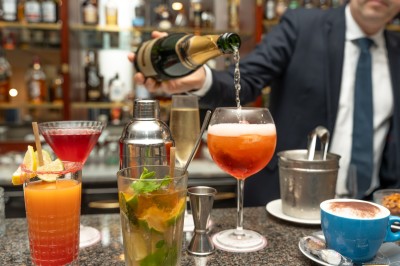 Buffet de petit-déjeuner avec viennoiseries, fromages, charcuterie, pain et confitures, dans une salle lumineuse.