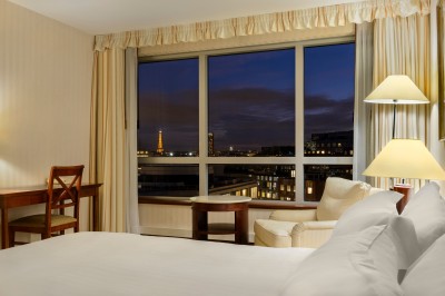 Buffet de petit-déjeuner avec viennoiseries, fromages, charcuterie, pain et confitures, dans une salle lumineuse.