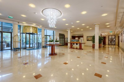 Buffet de petit-déjeuner avec viennoiseries, fromages, charcuterie, pain et confitures, dans une salle lumineuse.