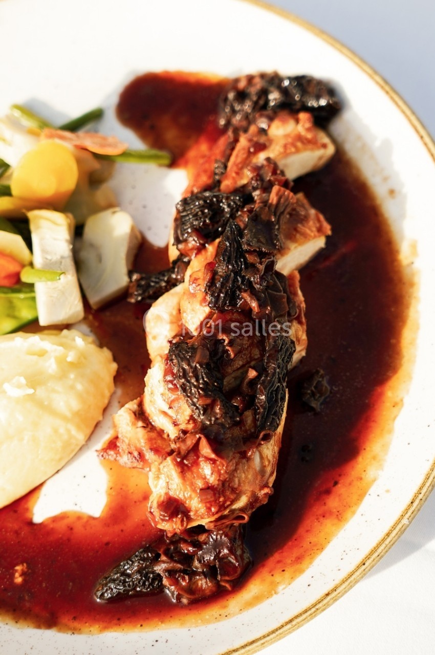 Plat de volaille nappée de sauce brune, accompagnée de purée et légumes variés sur une assiette blanche.