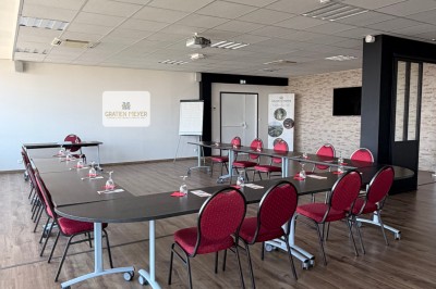 Table dressée avec cafetières, théière, tasses et condiments, placée près d'une fenêtre lumineuse.