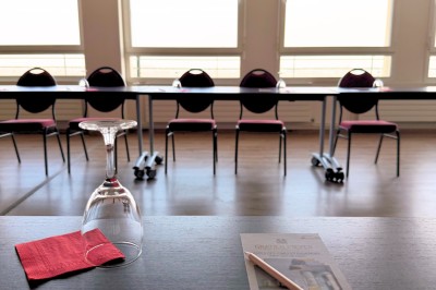 Table dressée avec cafetières, théière, tasses et condiments, placée près d'une fenêtre lumineuse.
