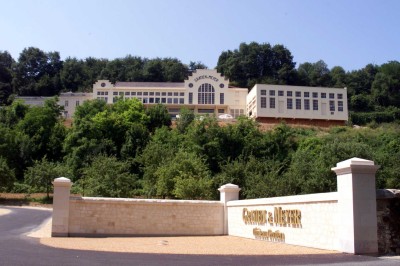 Table dressée avec cafetières, théière, tasses et condiments, placée près d'une fenêtre lumineuse.