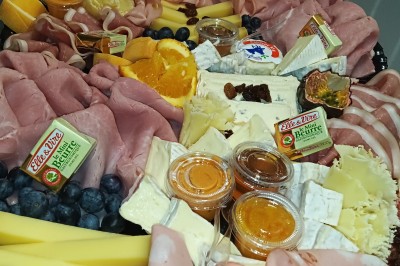 Plateaux garnis de charcuteries variées, cornichons et tranches de salami, présentés en trois tailles différentes.