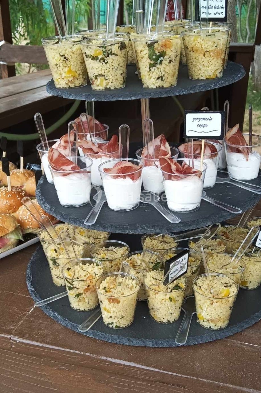 Buffet avec verrines de salades variées et desserts au yaourt, disposés sur un présentoir en ardoise.