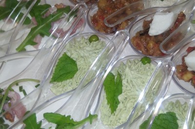 Plan de travail en acier inoxydable sous une fenêtre à double vitrage, dans une pièce aux murs carrelés effet marbre.