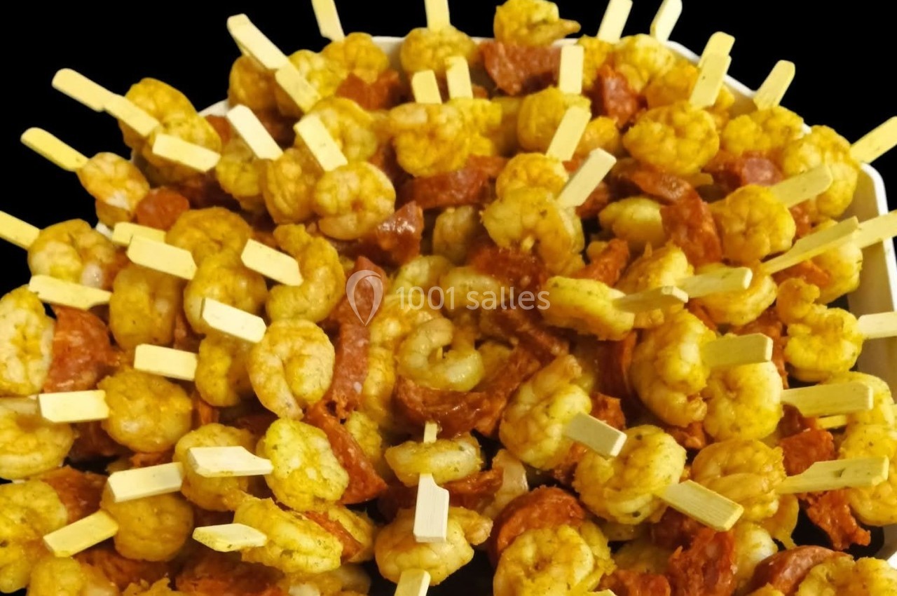 Brochettes apéritives composées de crevettes assaisonnées et de rondelles de chorizo sur des pics en bois.