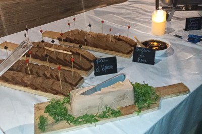 Plan de travail en acier inoxydable sous une fenêtre à double vitrage, dans une pièce aux murs carrelés effet marbre.