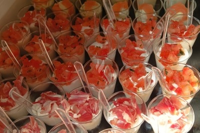 Plan de travail en acier inoxydable sous une fenêtre à double vitrage, dans une pièce aux murs carrelés effet marbre.